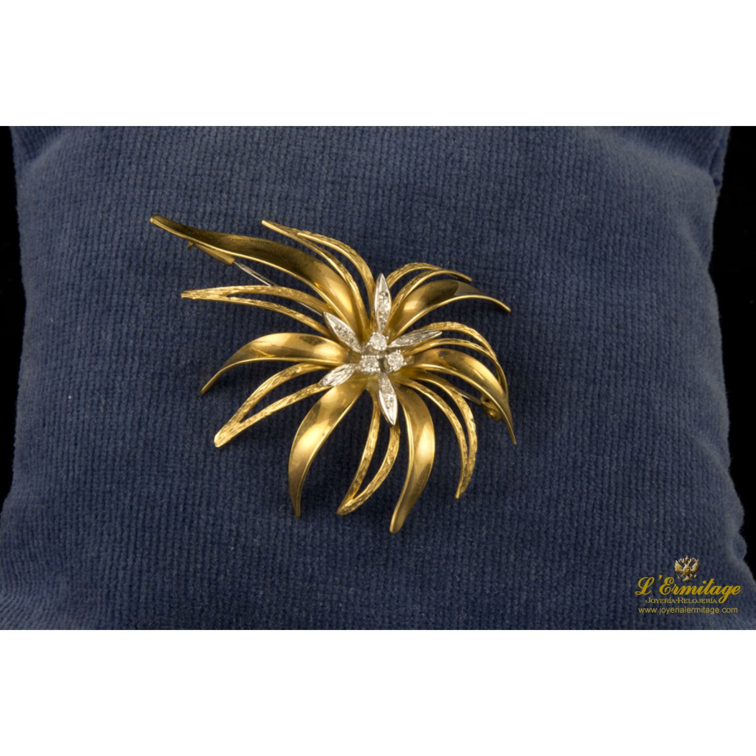 Broche tipo hojas con centro de brillante en oro amarillo