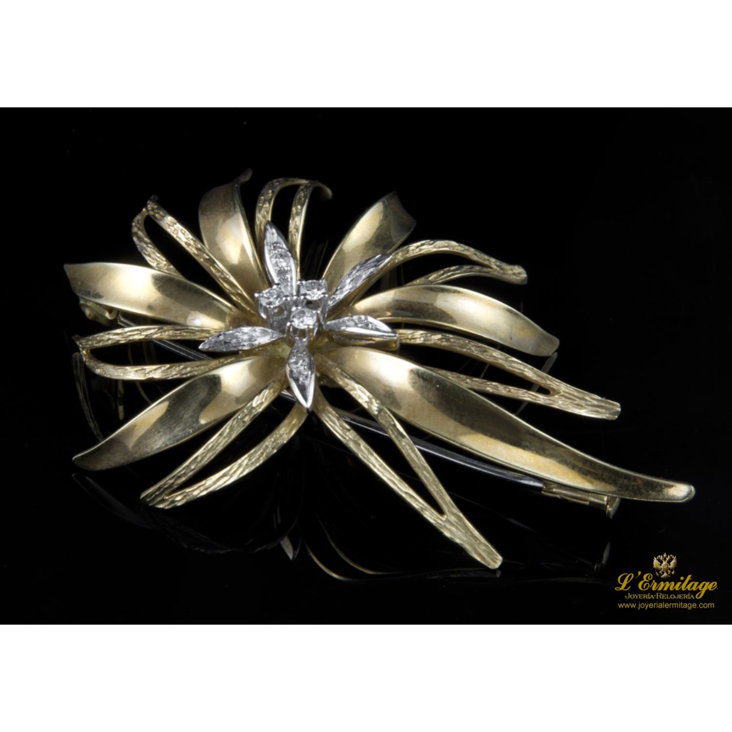 Broche tipo hojas con centro de brillante en oro amarillo