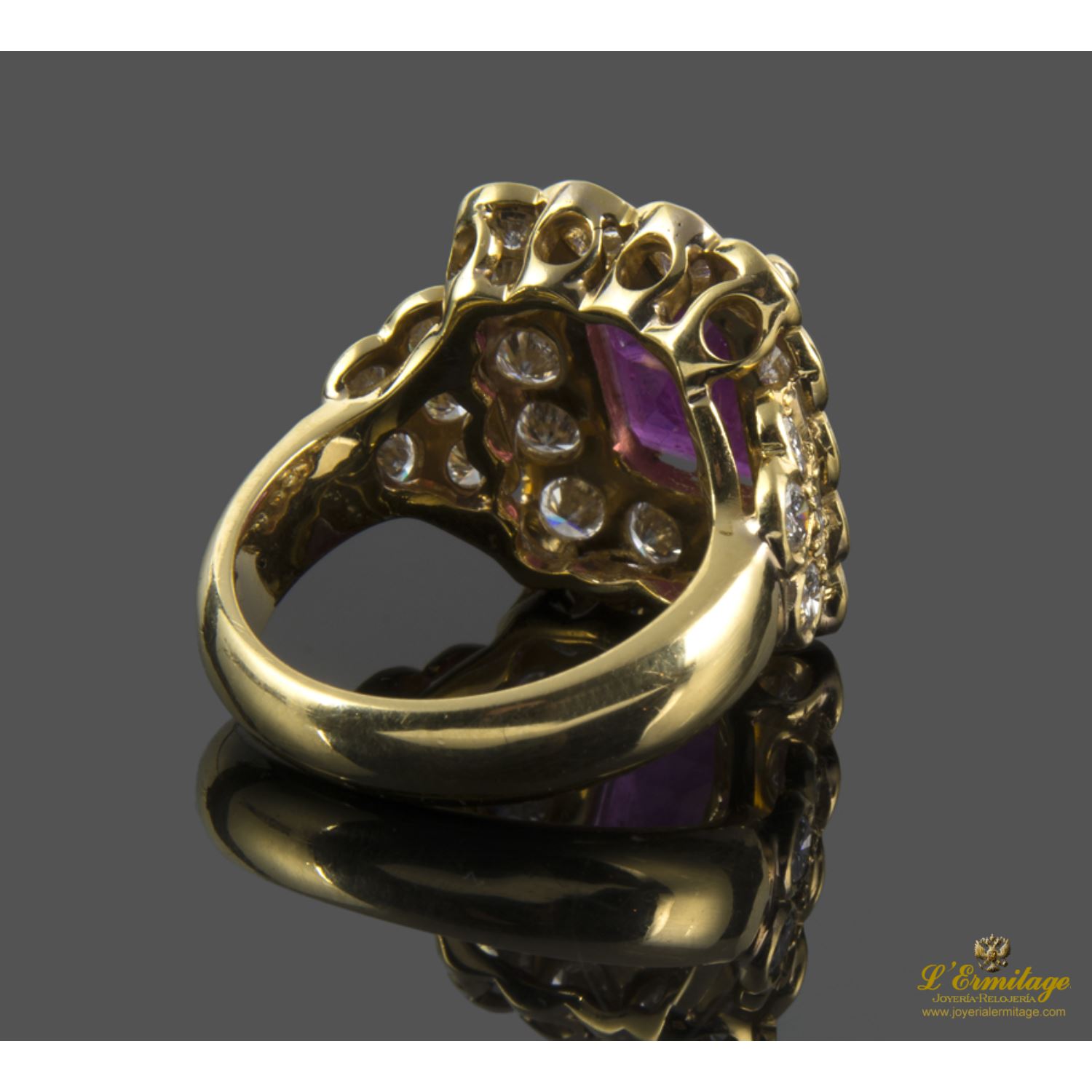 Sortija realizada en oro amarillo. Presenta un rubí central natural y orla de brillantes.