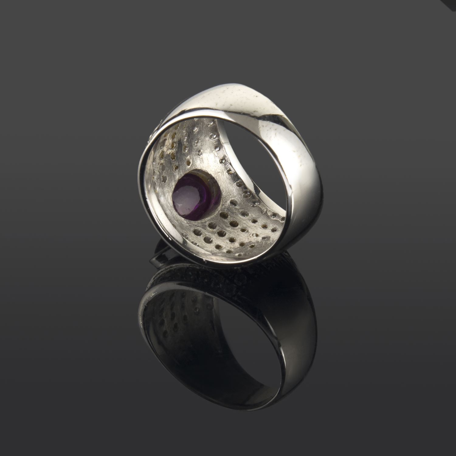 Sortija en oro blanco con un rubi central y motivos con brillantes dispuestos en fila