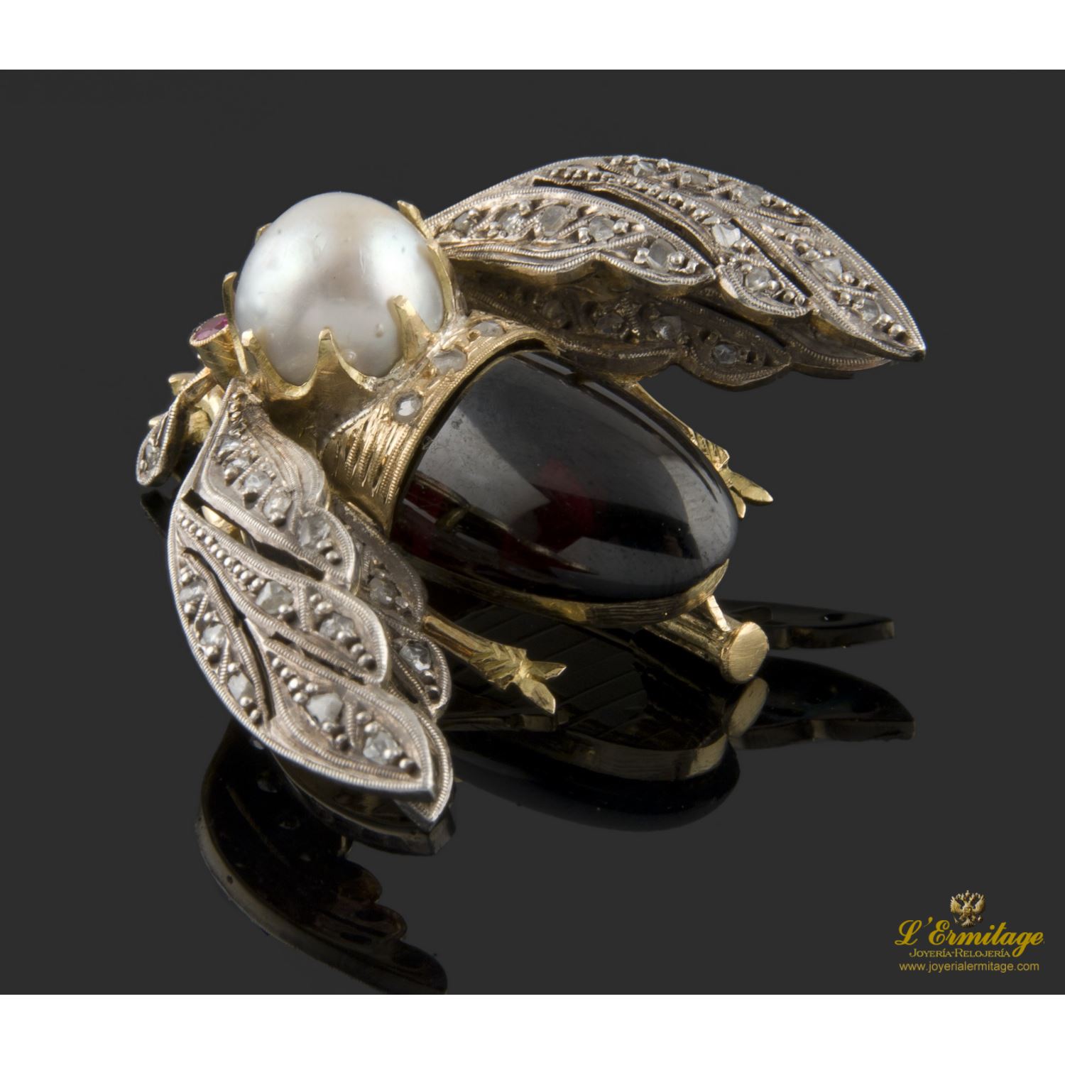 Broche en forma de abejorro realizado en oro amarillo y plata. Presenta perla, grate rojo, rubíes y diamantes.