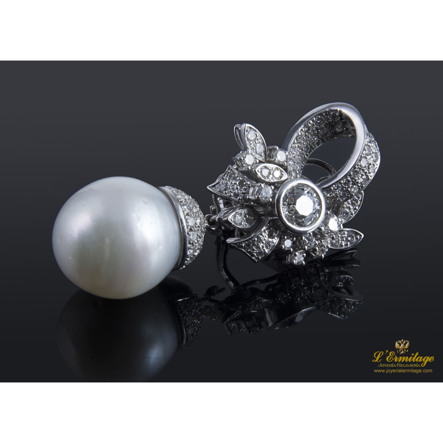 Pendientes desmontables en forma de lazo realizados en oro blanco. Presenta perlas australianas y brillantes.