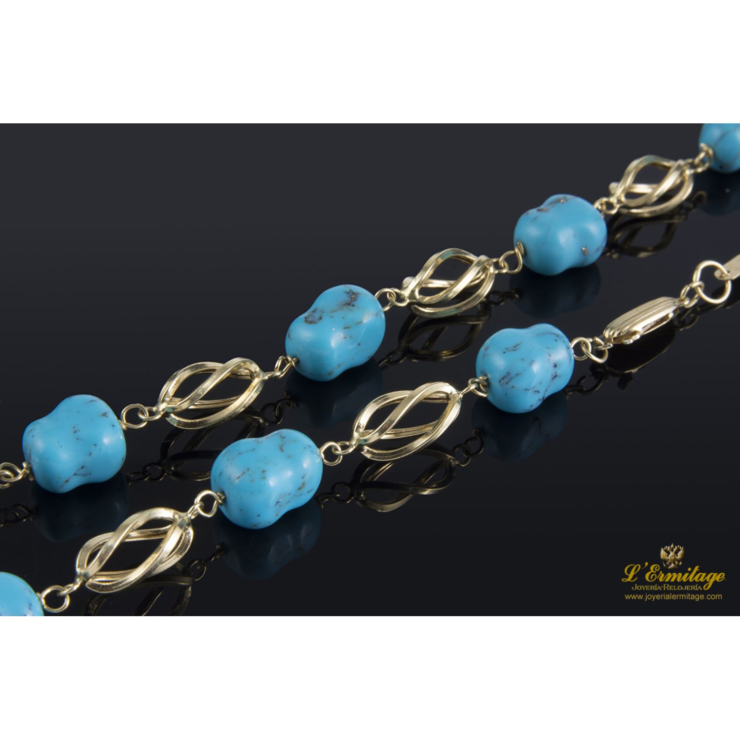 Collar realizado en oro amarillo con eslabones en forma de jaula y presenta turquesas naturales.