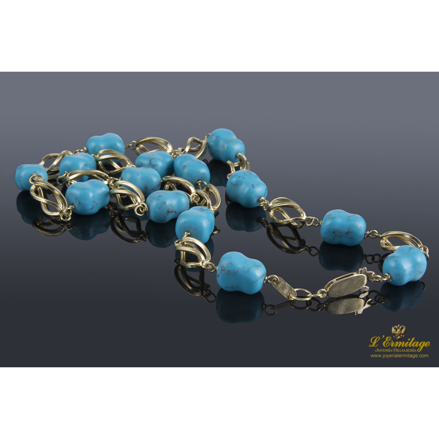 Collar realizado en oro amarillo con eslabones en forma de jaula y presenta turquesas naturales.