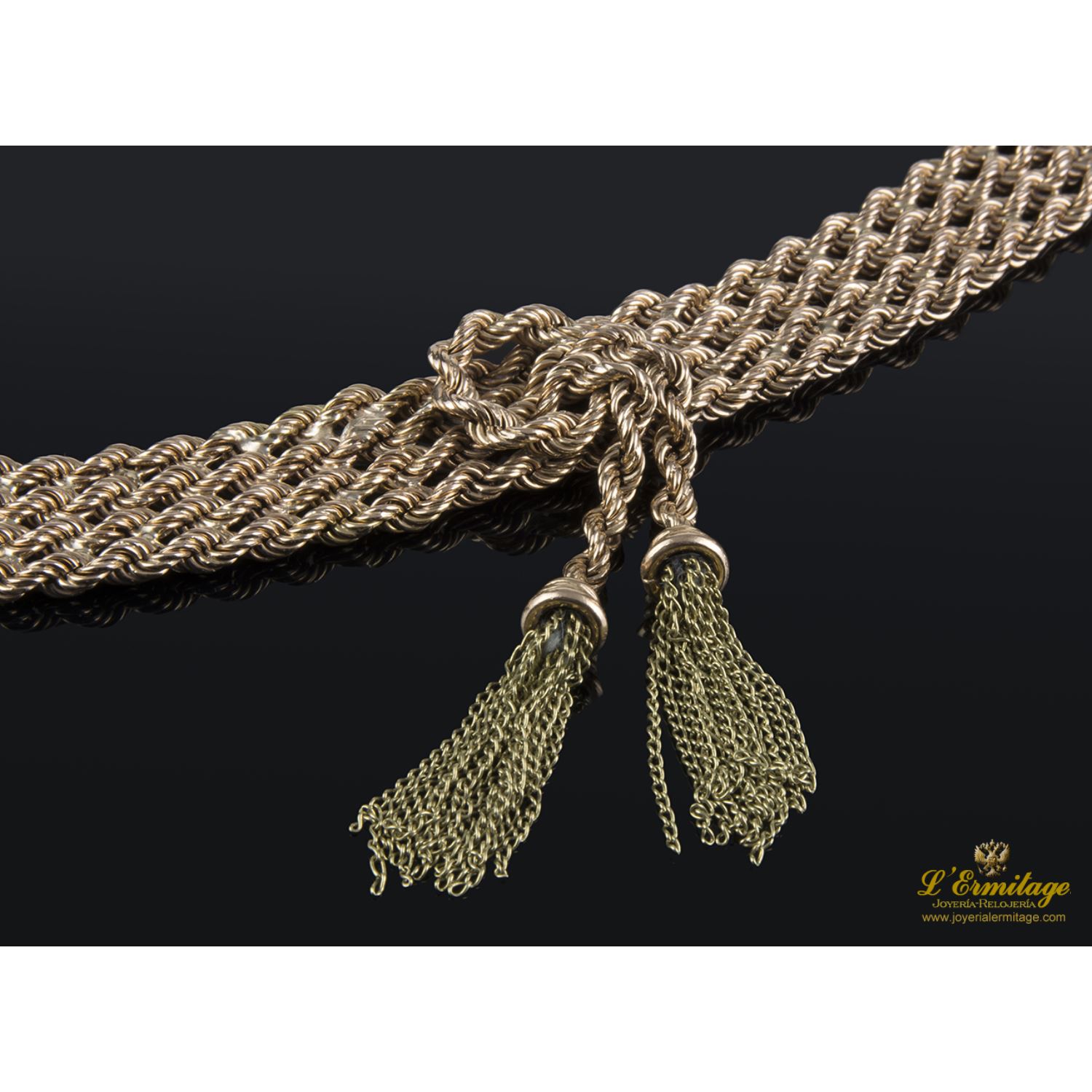 Pulsera realizada en oro rosa y oro amarillo con forma de cuatro trenzas en fila con un nudo y flecos.