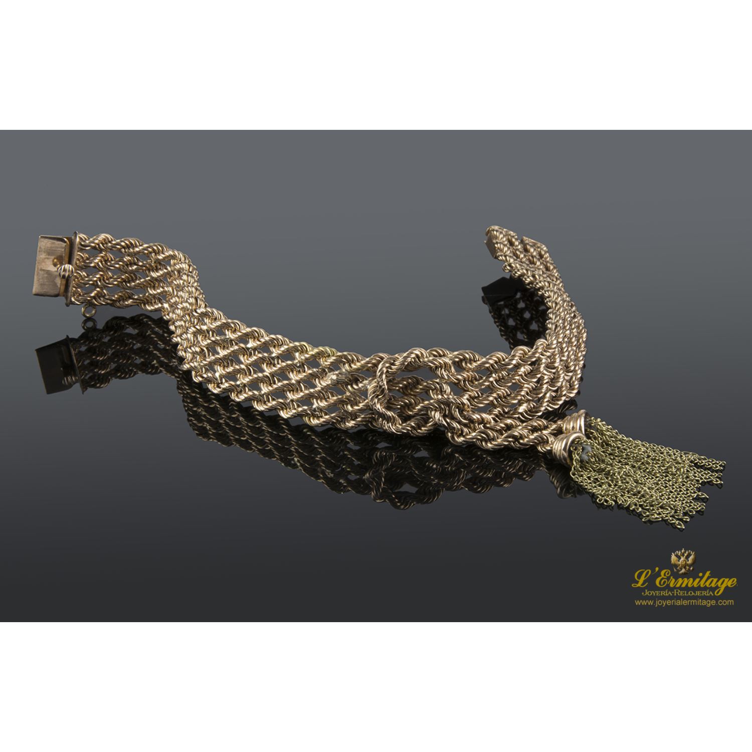 Pulsera realizada en oro rosa y oro amarillo con forma de cuatro trenzas en fila con un nudo y flecos.