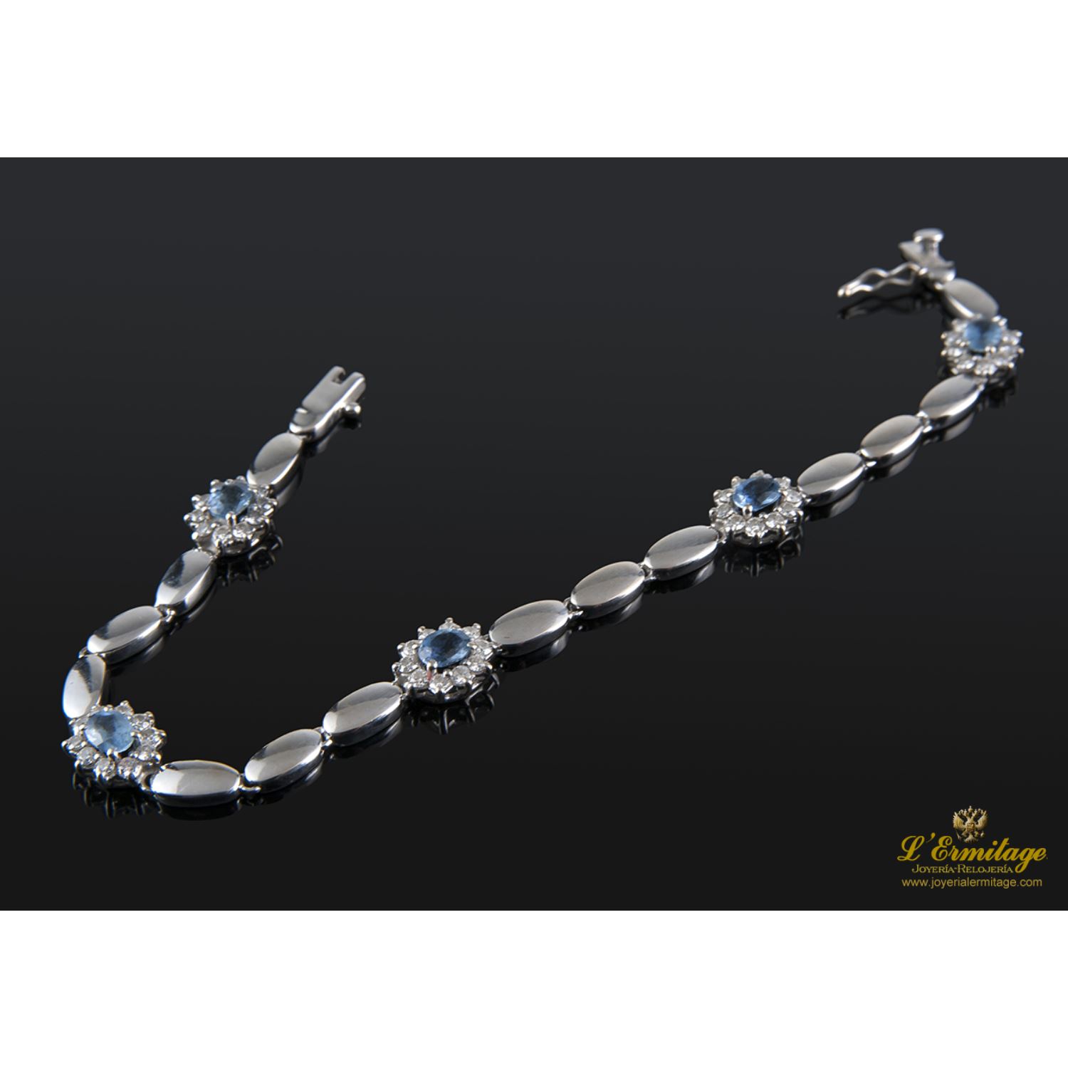 Pulsera realizada en oro blanco con rosetas de agua marina y brillantes.