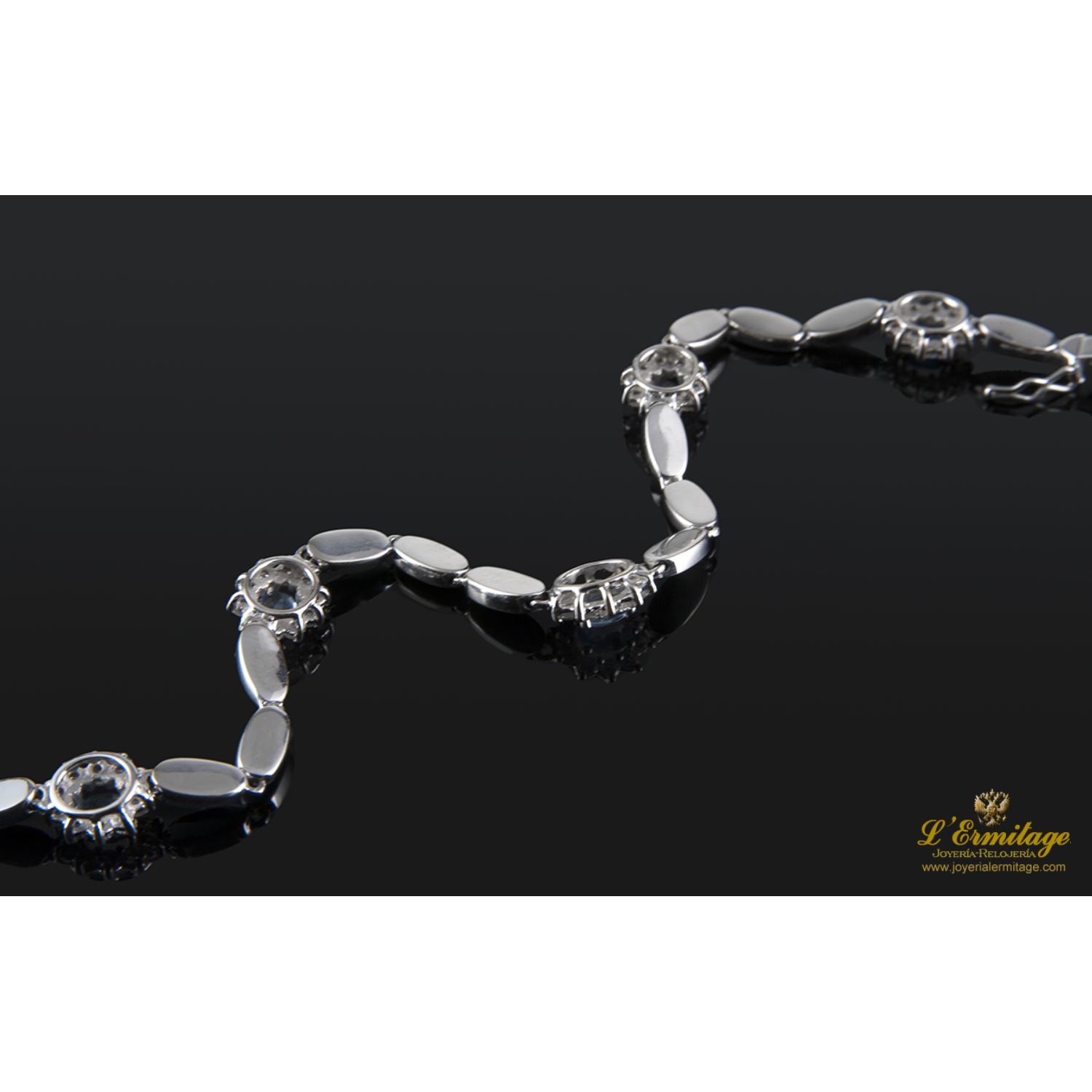 Pulsera realizada en oro blanco con rosetas de agua marina y brillantes.