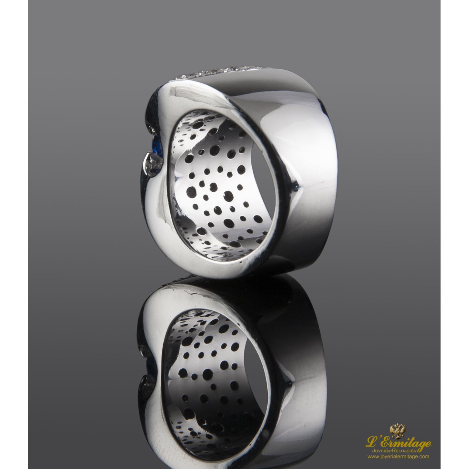 Sortija realizada en oro blanco. Presenta un zafiro natural y brillantes