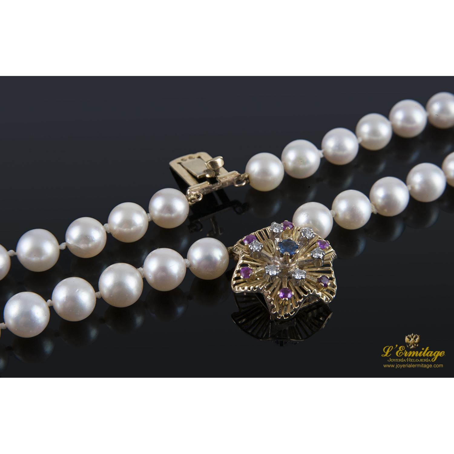 Pulsera de perlas con cierre en oro amarillo con forma de flor.