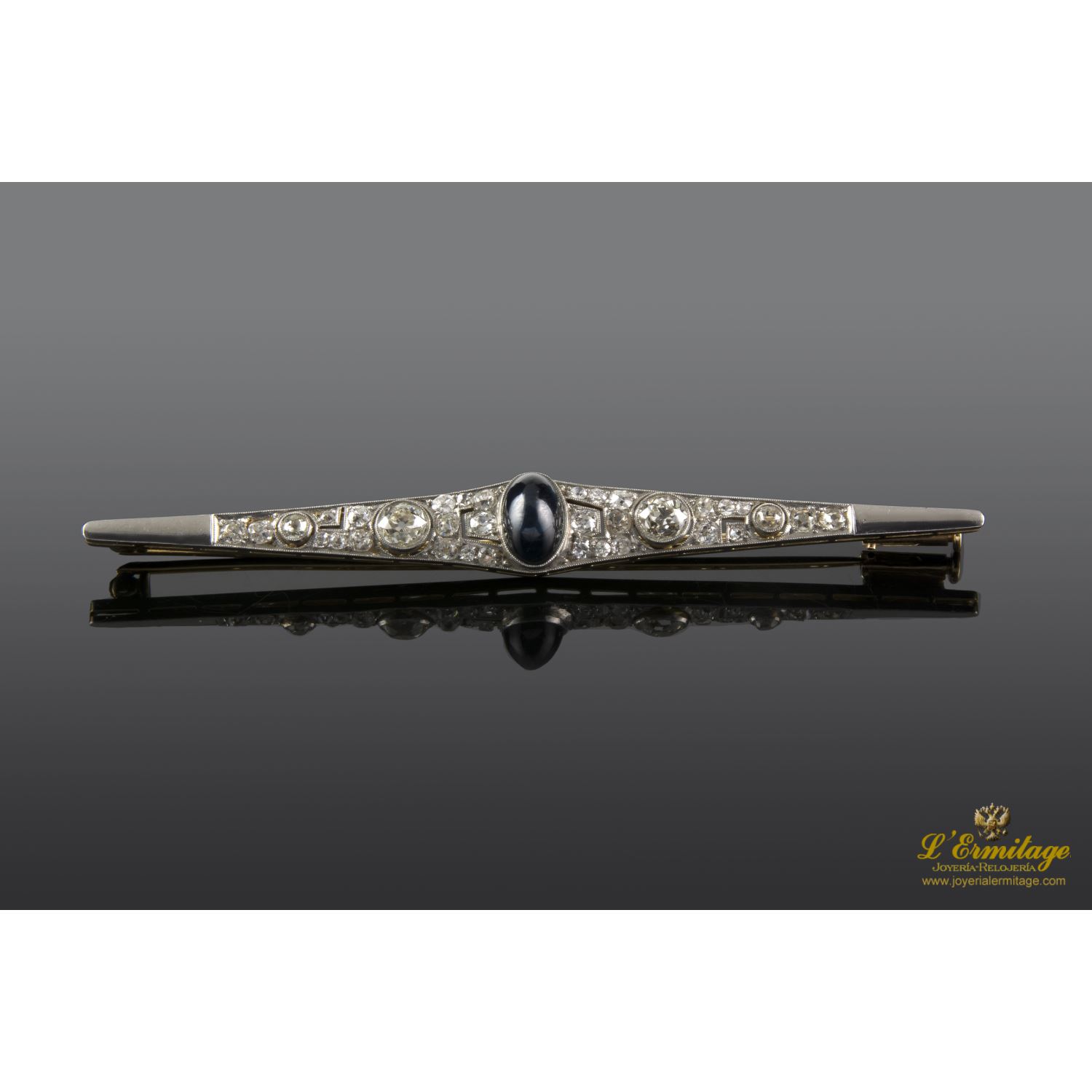 Broche-alfiler antiguo oro amarillo, oro blanco, zafiro cabuchón y diamantes.