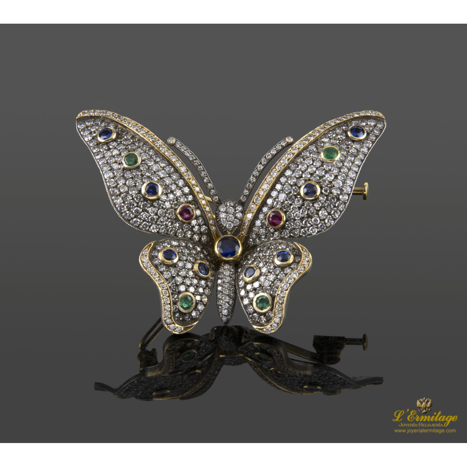 Broche-alfiler mariposa en oro amarillo y plata con rubíes, esmeraldas, zafiros y diamantes naturales.