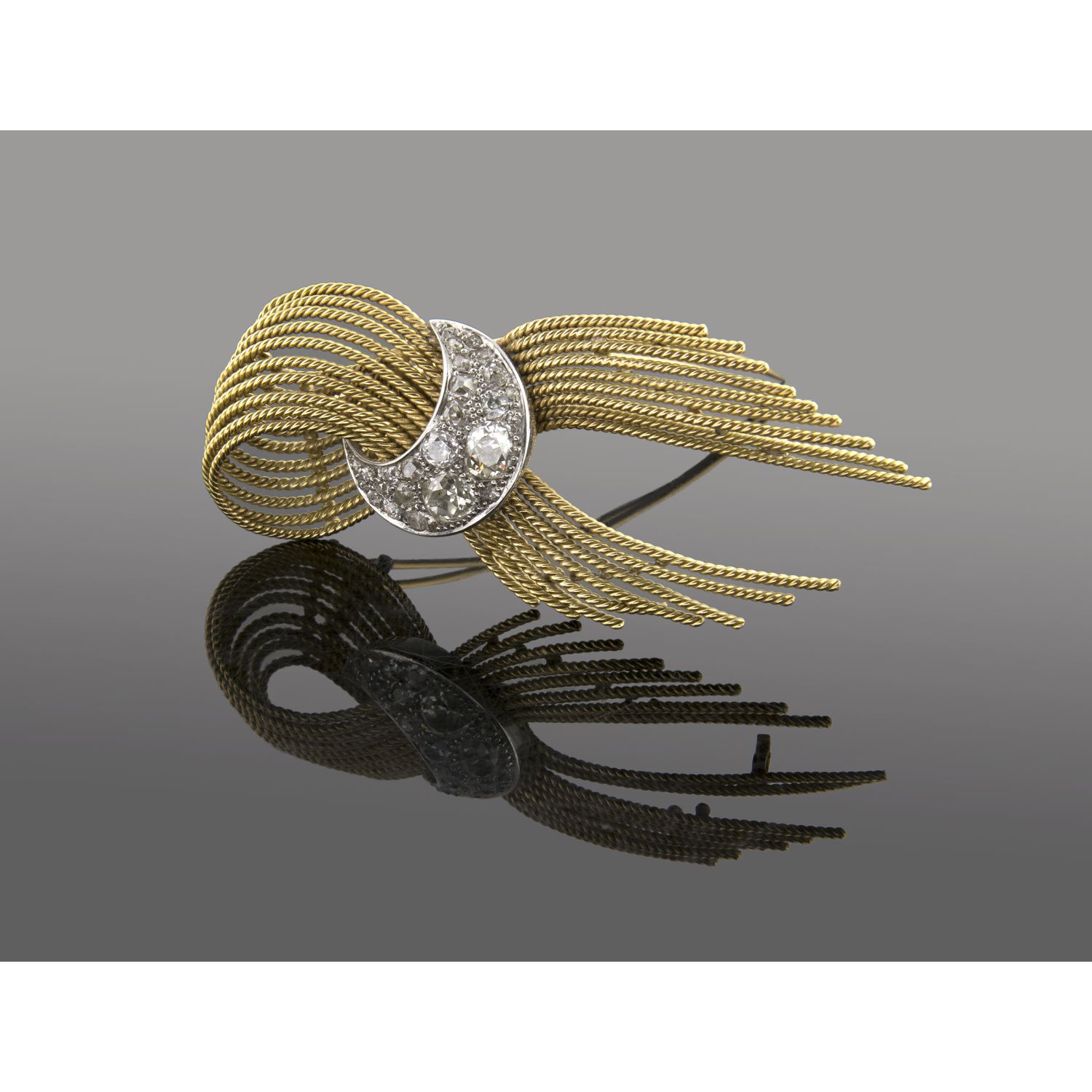 Broche-alfiler lazo con medialuna en oro amarillo y oro blanco con diamantes.