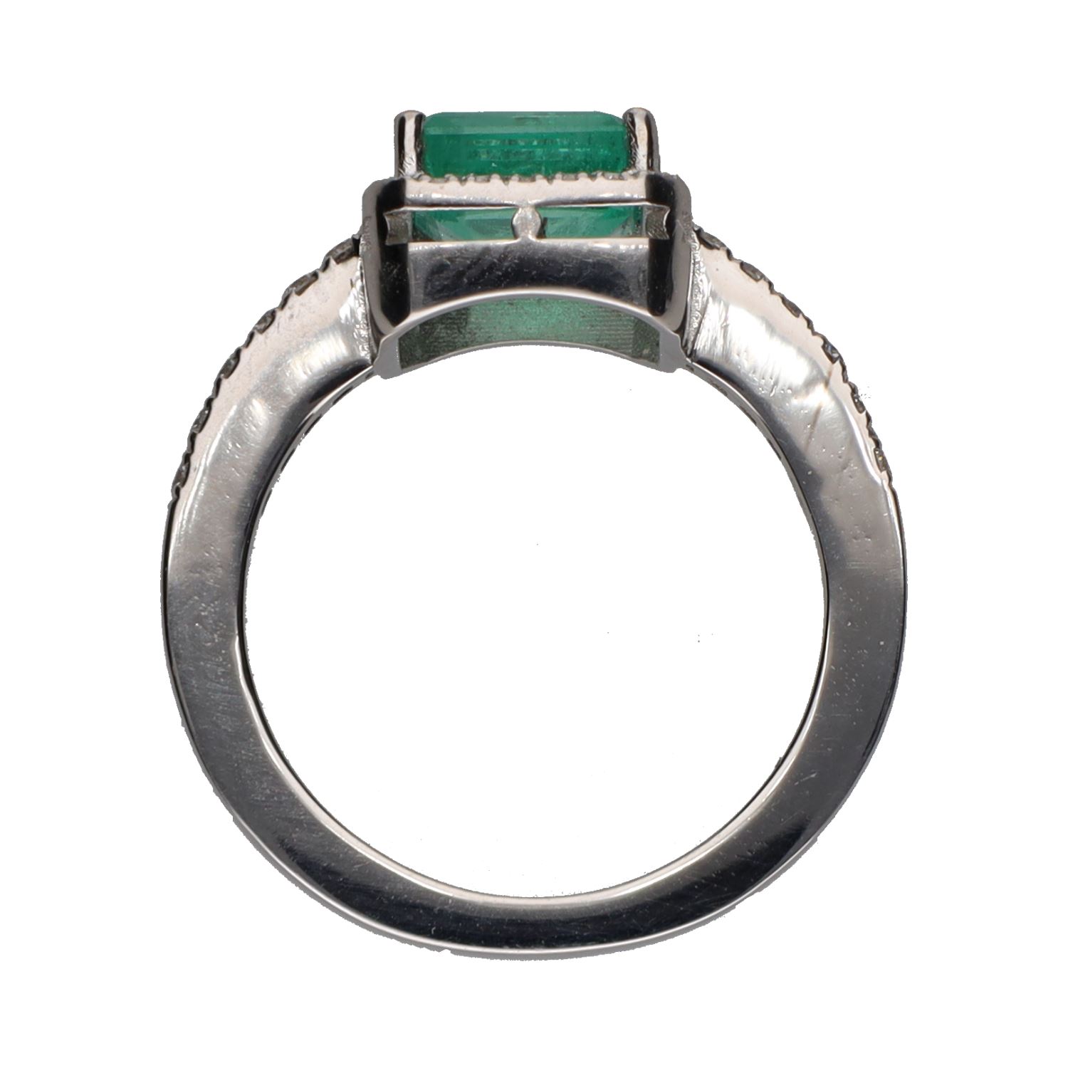 Sortija con esmeralda central y brillantes en orla y brazos. Talla 13.