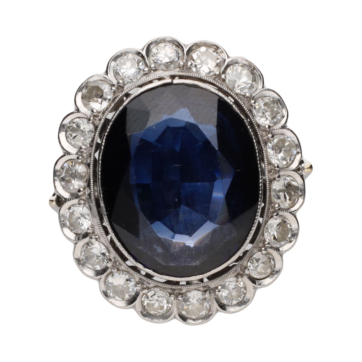 Sortija antigua en oro blanco con cristal azul central y orla de diamantes. Talla 10.