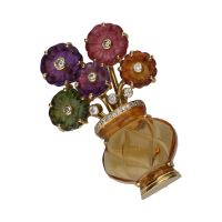 Broche forma de jarron con flores en oro amarillo y piedras de color.