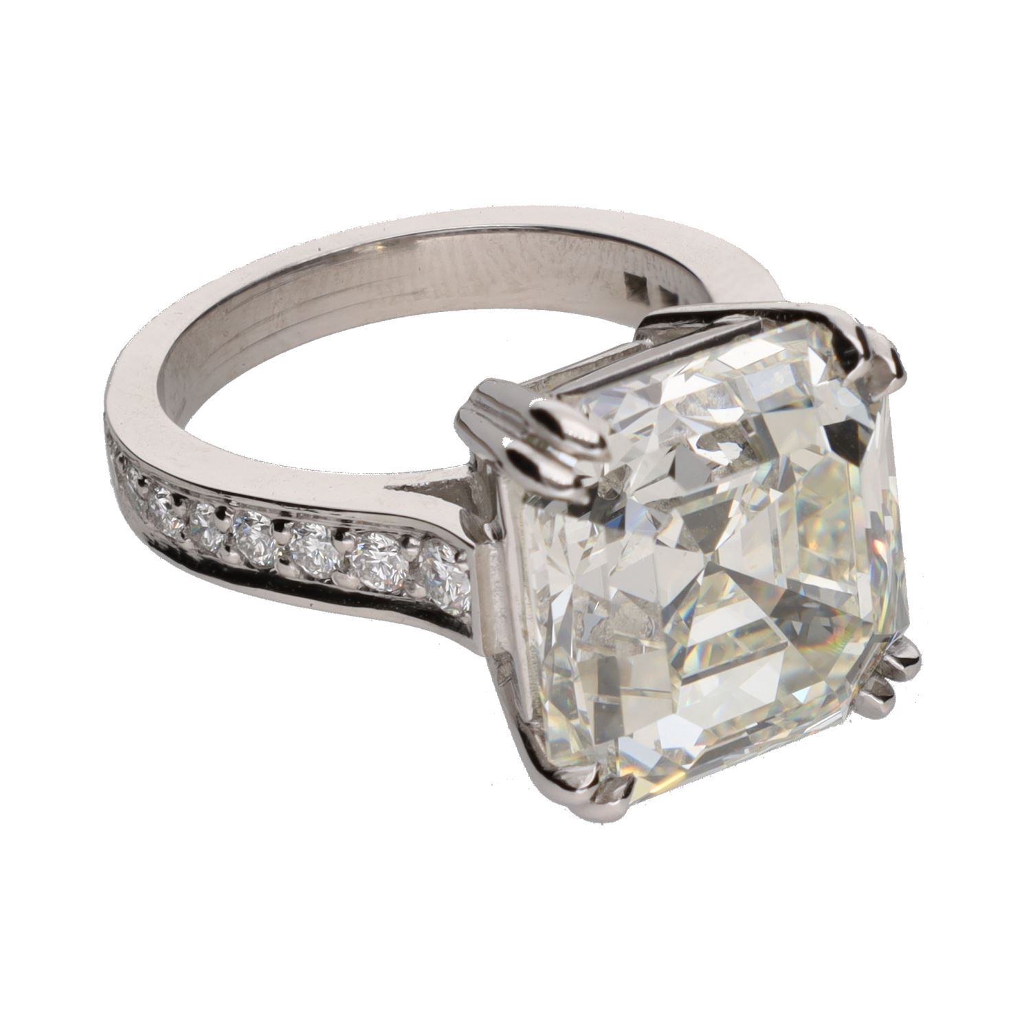 Sortija en platino con diamantes talla esmeralda central y brillantes.