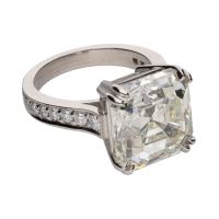 Sortija en platino con diamantes talla esmeralda central y brillantes.