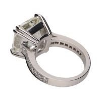 Sortija en platino con diamantes talla esmeralda central y brillantes.