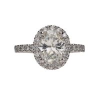 Sortija en platino con diamante oval y orla de brillantes. Talla 11.