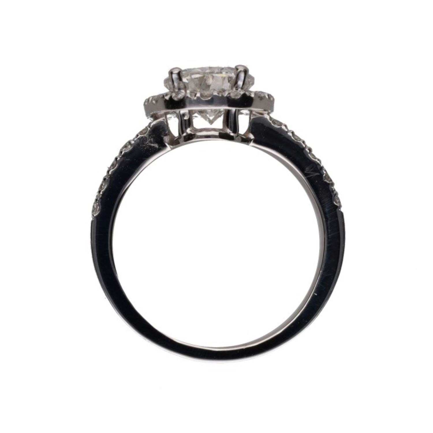 Sortija en platino con diamante oval y orla de brillantes. Talla 11.